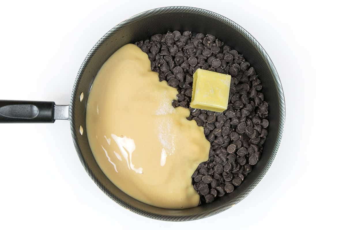 Dark chocolate chips, sweetened condensed milk, unsalted butter, and salt in a saucepan.