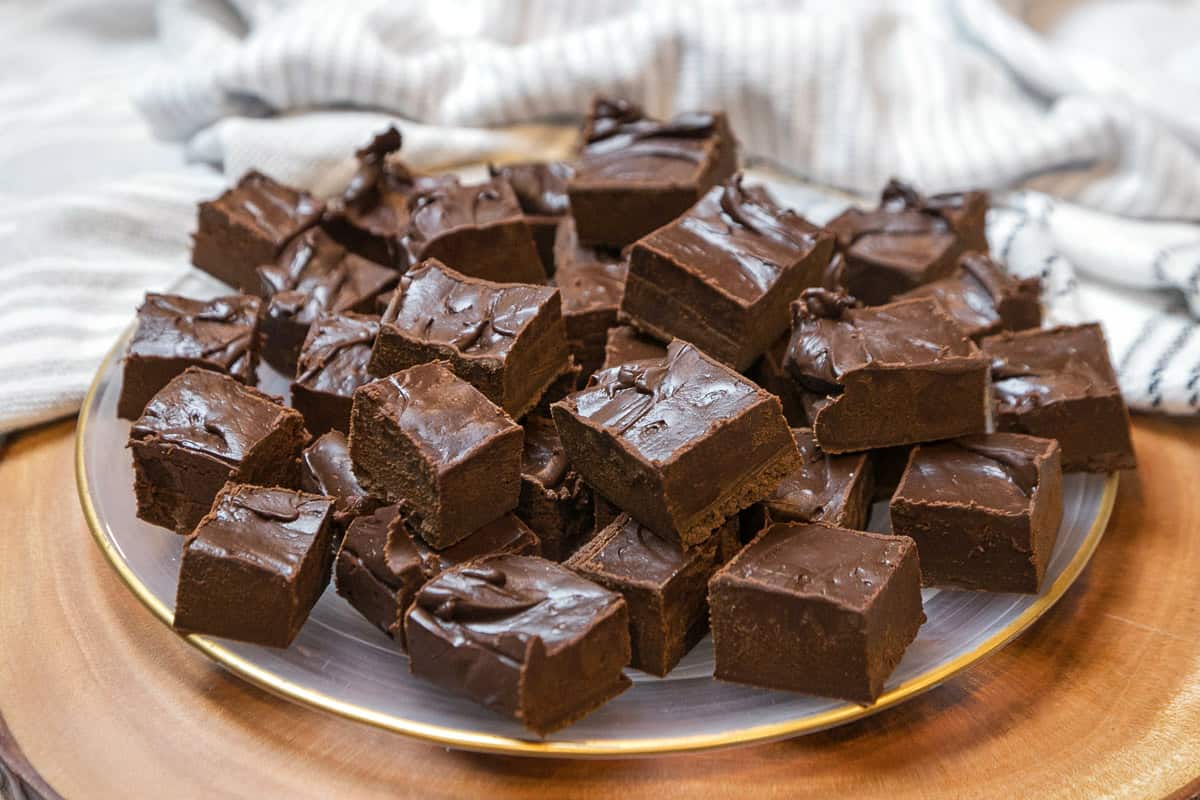 Dark chocolate fudge cut into squares on a plate.