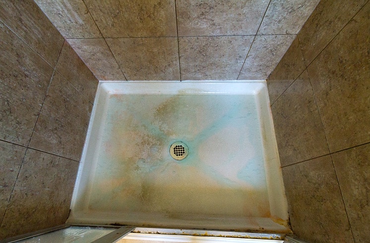 dirty shower pan with homemade cleaner soaking