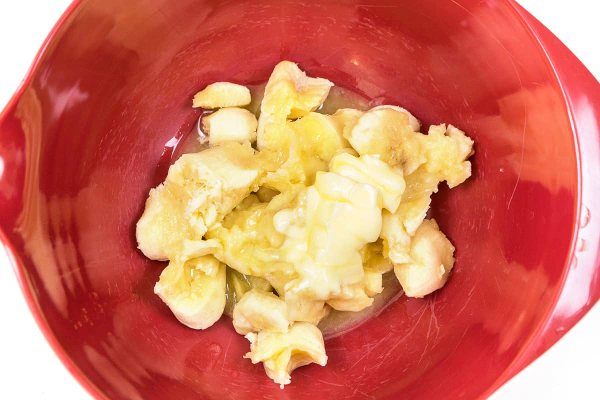 The butter is added to the bowl with the bananas.