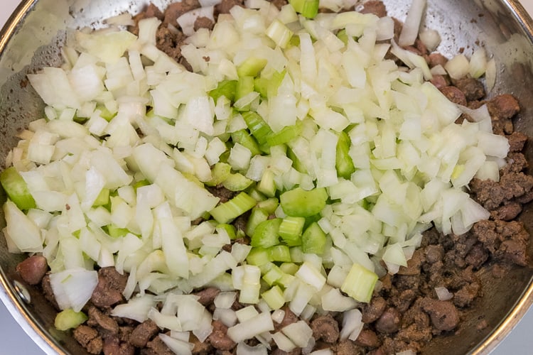 Add the diced onion and celery to the browned liver and chicken hearts.