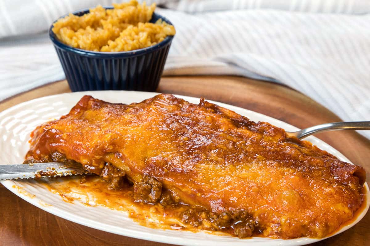 A beef enchilada on a plate.