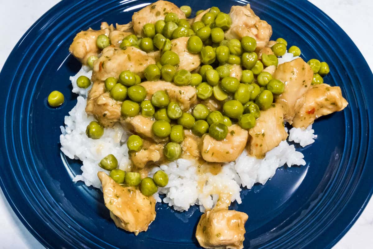 General Tso's Chicken Final Dish on white rice with peas.