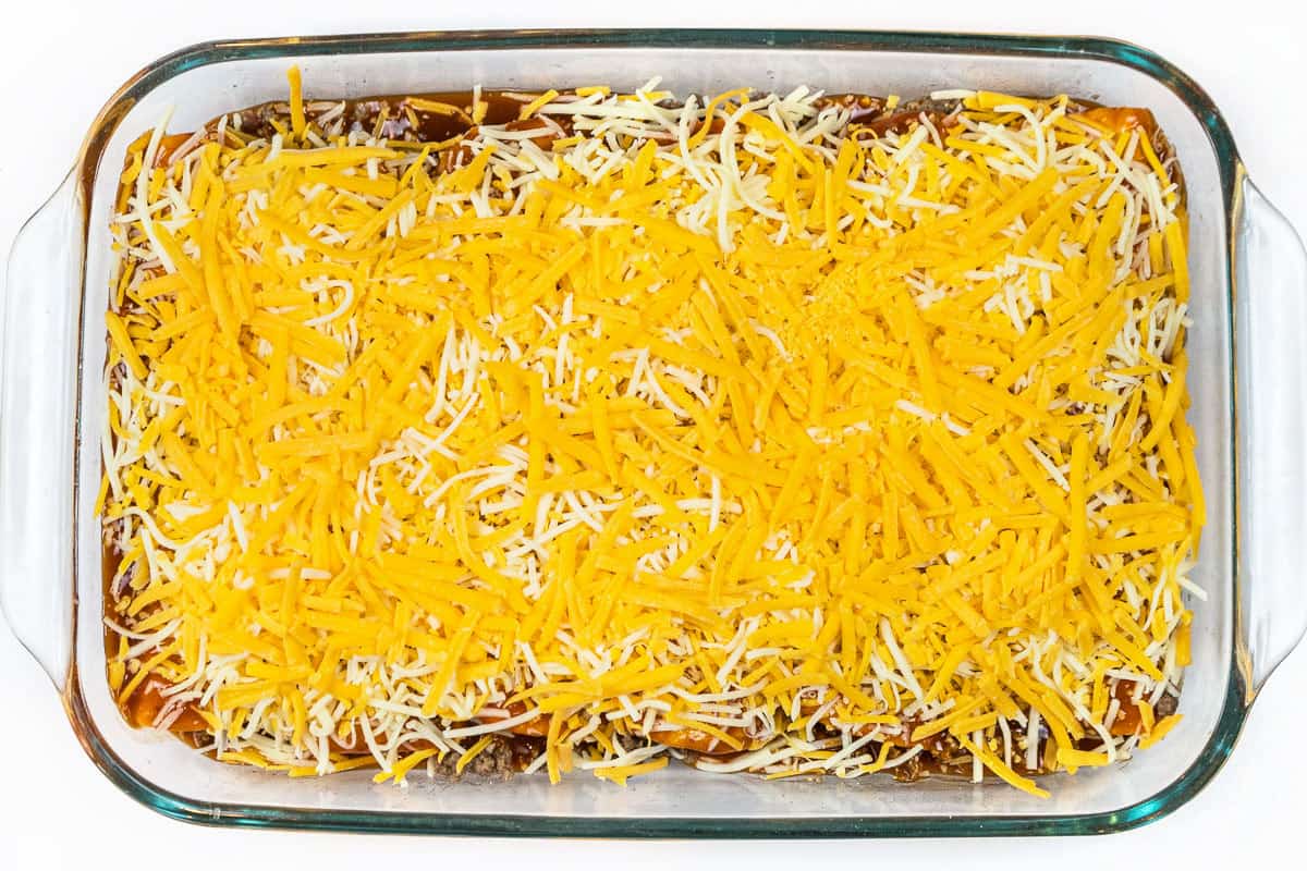 Sprinkle the cheddar cheese over the top of the Mexican cheese blend.