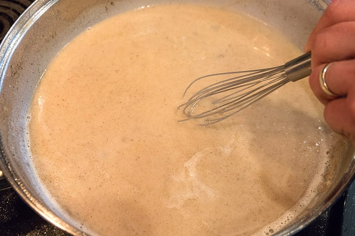Add two and a half cups of water and one-half cup of milk with the browned flour mixture.