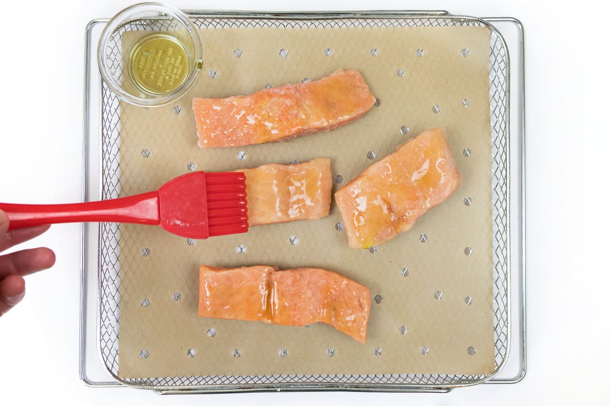 Brush olive oil on salmon fillets until completely coated.
