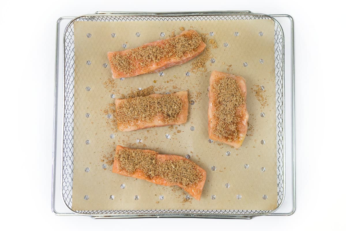 The seasonings are sprinkled on top of the salmon fillets.
