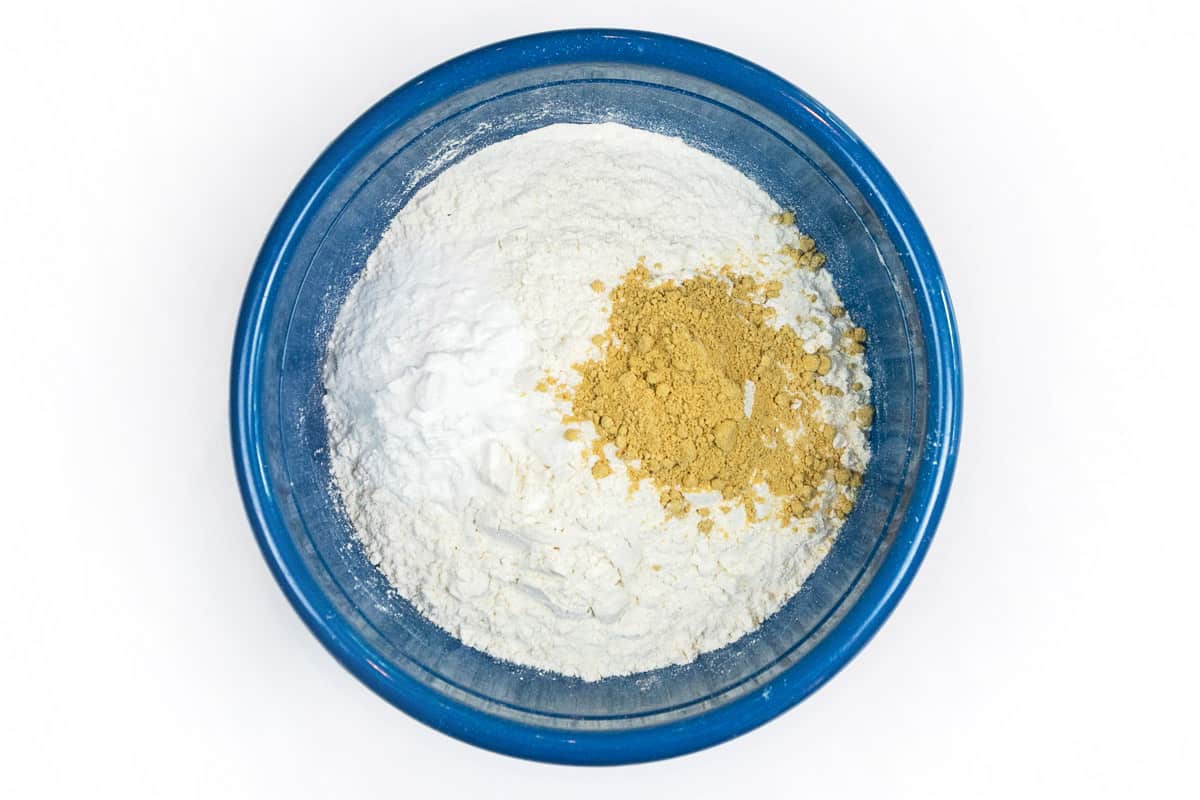 All-purpose flour, baking powder, baking soda, and ground ginger in a bowl.
