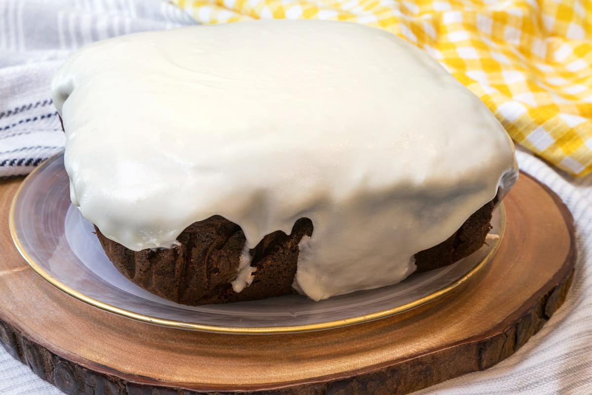 Gingerbread cake with cream cheese frosting on a plate.