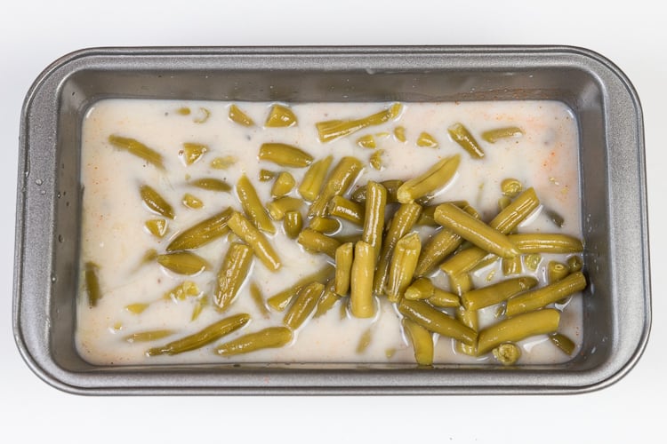 Green beans are added to the loaf pan.