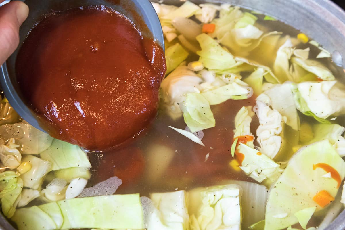 Add the ketchup to the pot of soup.