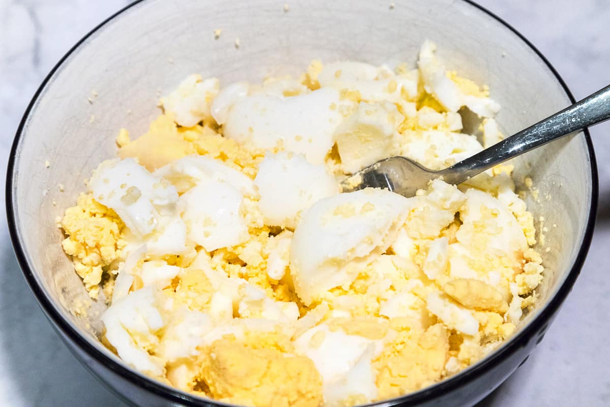 Hard-boiled eggs mixed in a bowl.