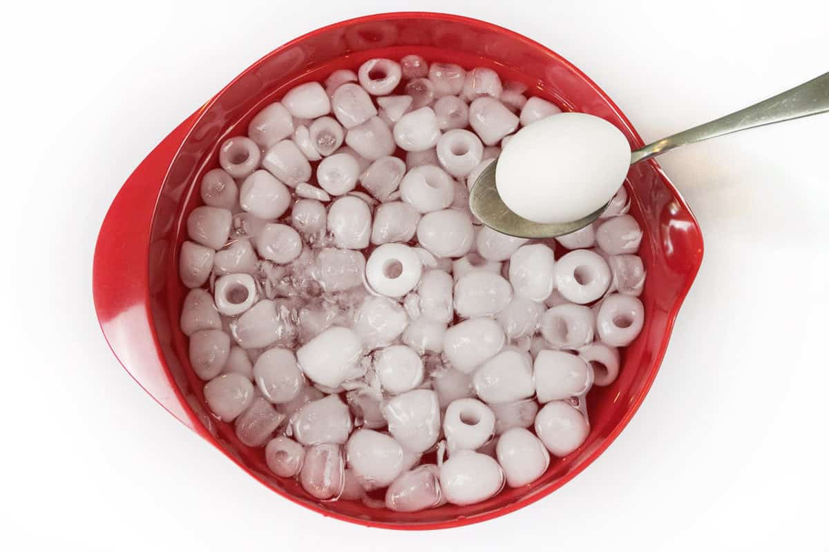 Place the hard-boiled eggs in the bowl with the ice cubes and water.