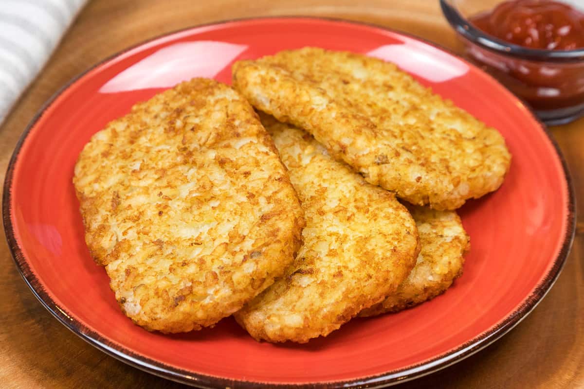 Four hash browns on a plate.