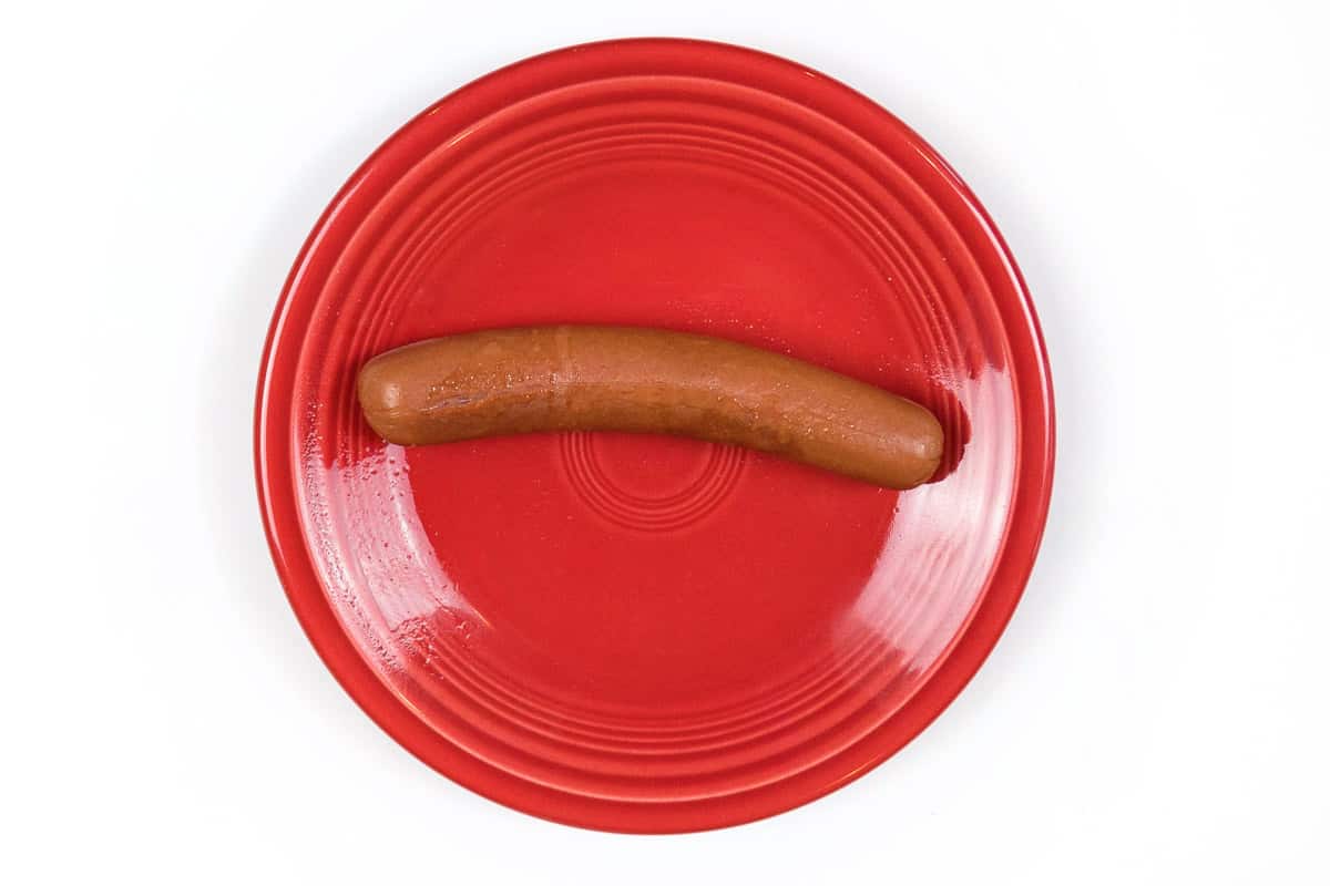 A cooked hot dog on a plate.
