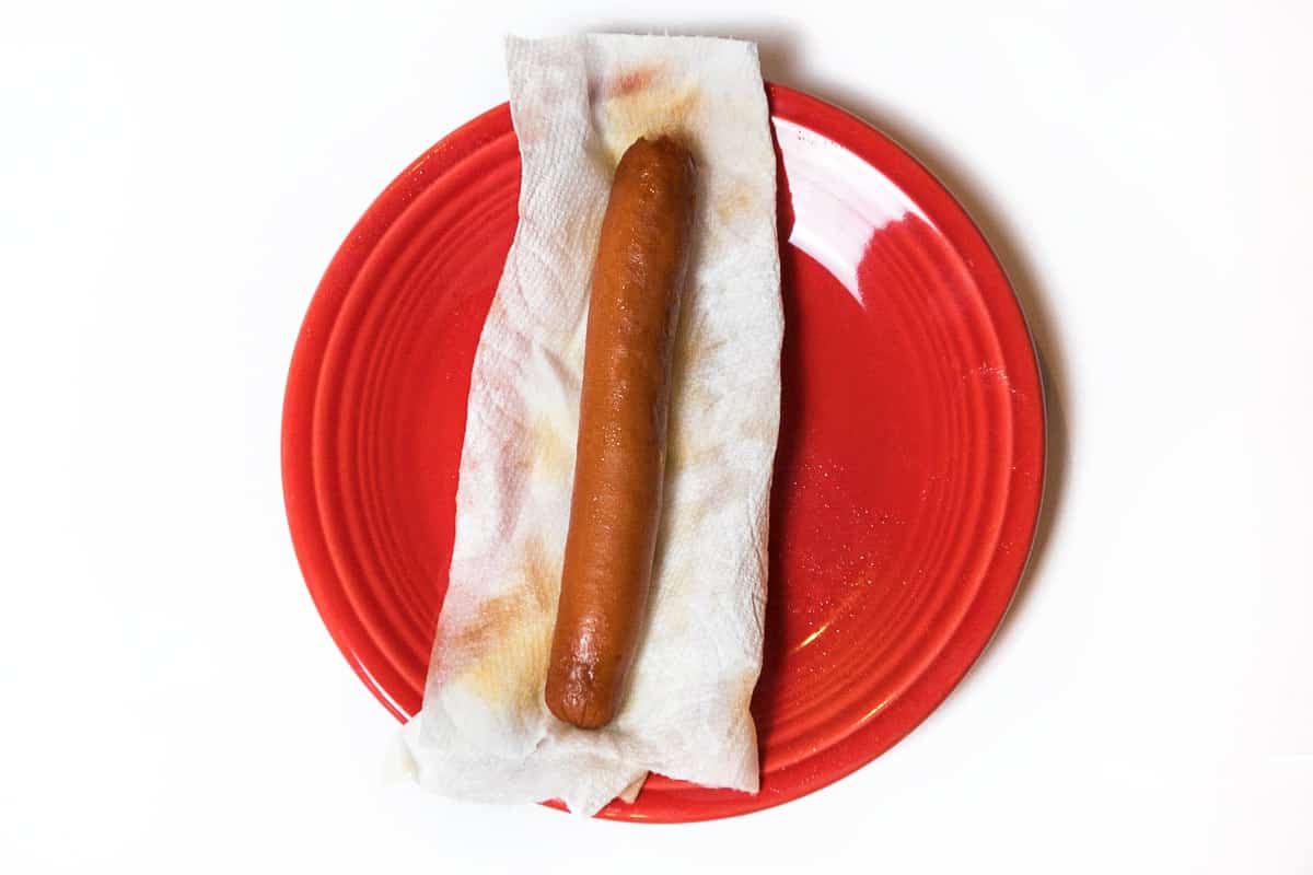 A refrigerated hot dog in a dry paper towel.