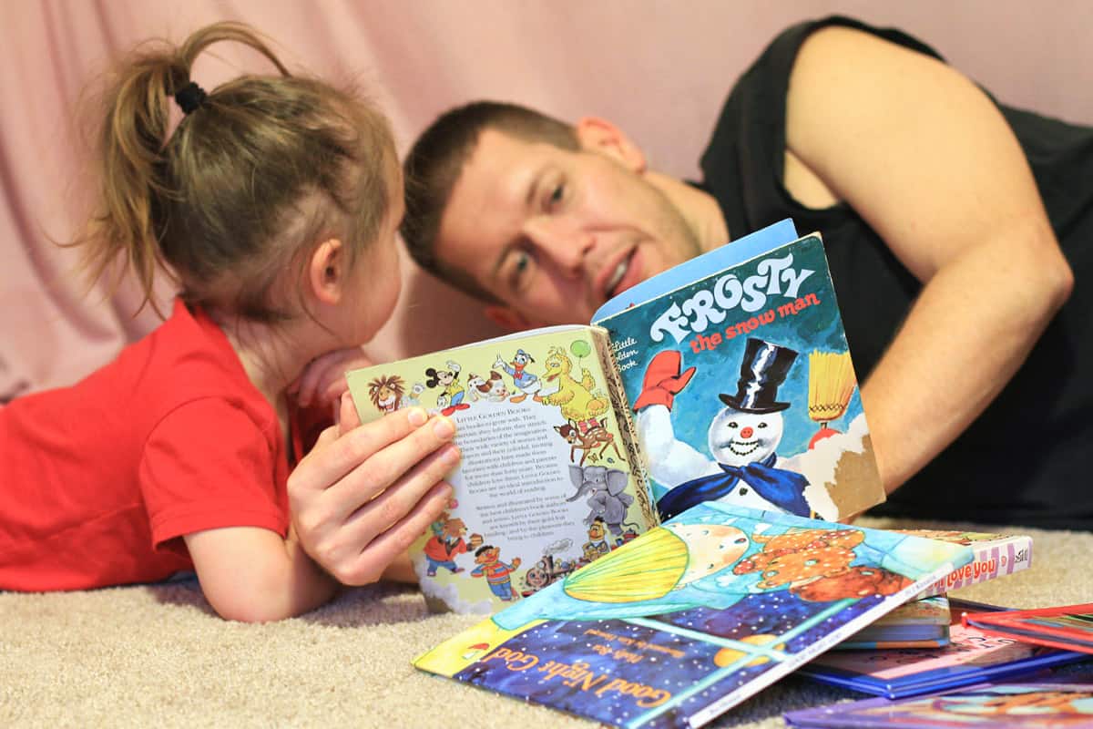 Father reading to his 3 year old daughter.