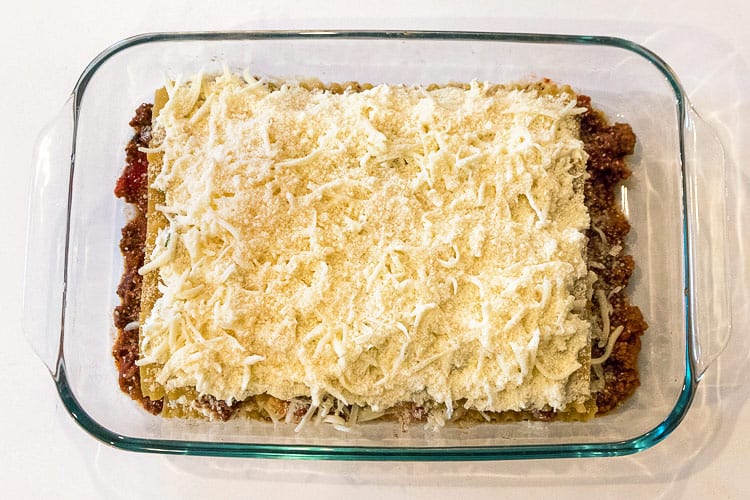 The last layer of Parmesan cheese is added to the baking dish.