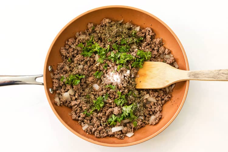 Parsley, basil, and sugar are added to the ground beef mixture.