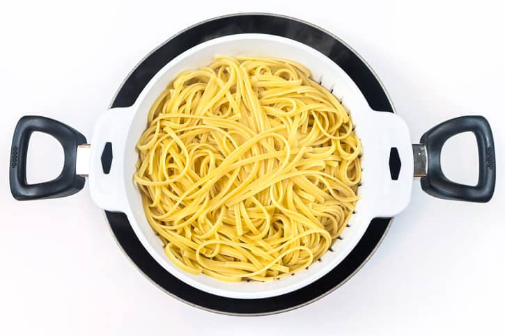 Cooked linguine pasta in a colander.