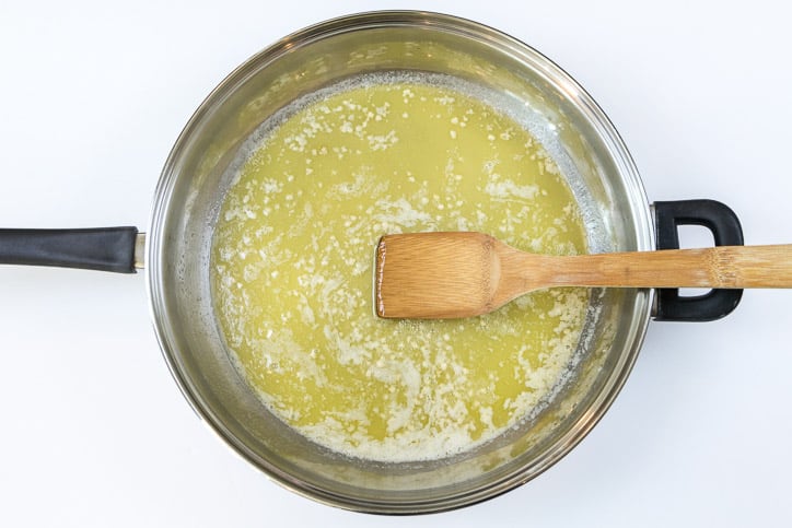 Melted butter and cooked minced garlic in a frying pan.