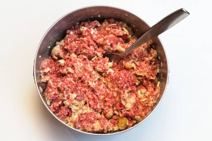 Mix lean ground beef, milk, egg whites, pieces of bread, and crumbled saltine crackers.