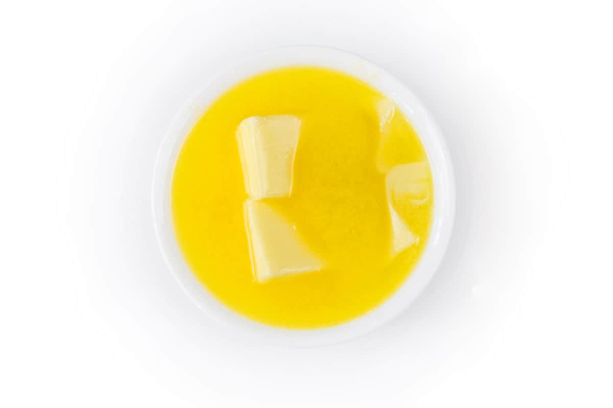 One cup of melted butter in a bowl.