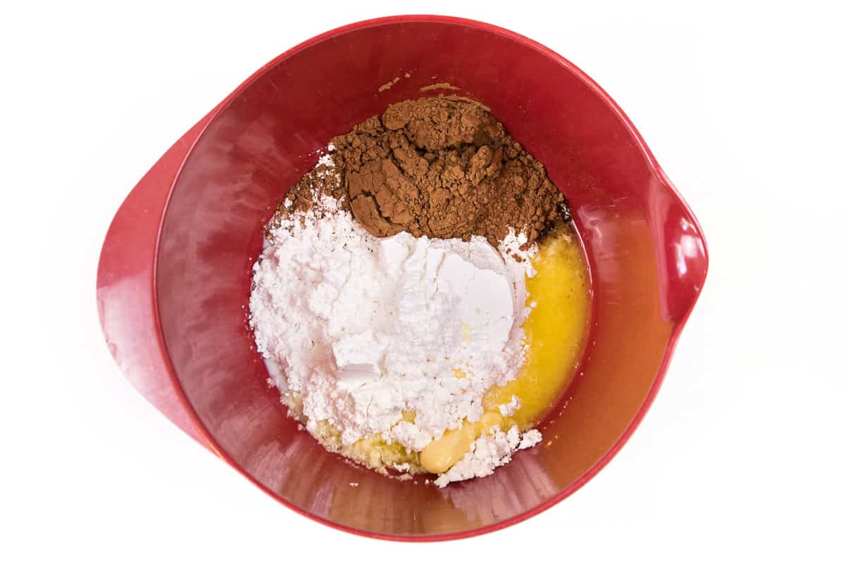 Put melted butter together with two and one-half cups of powdered sugar, one-half cup of milk, and one-third cup of unsweetened cocoa powder in a bowl.