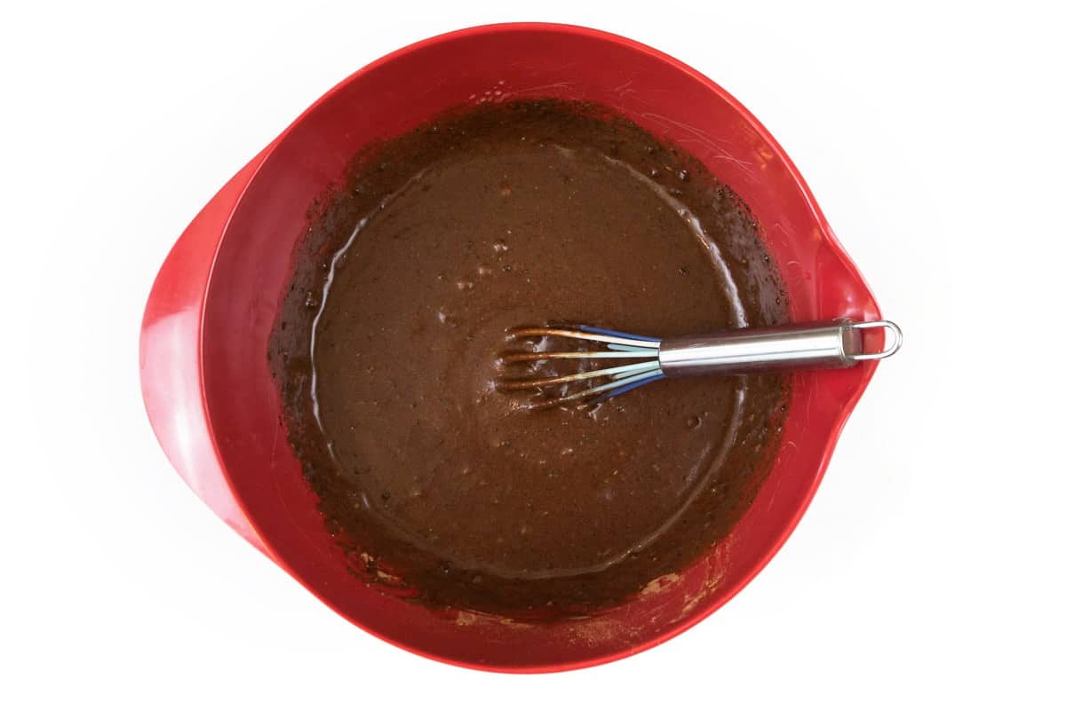 Melted butter, granulated sugar, unsweetened cocoa powder, salt, eggs, and vanilla extract are mixed well in a bowl.