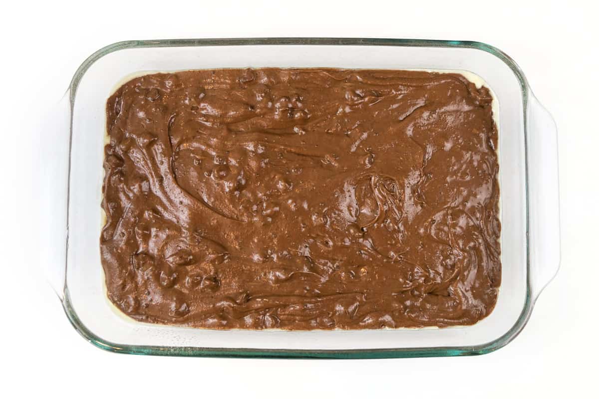 Put the chocolate cake batter into a greased nine by thirteen baking pan. Bake at three hundred and fifty degrees Fahrenheit for thirty minutes.