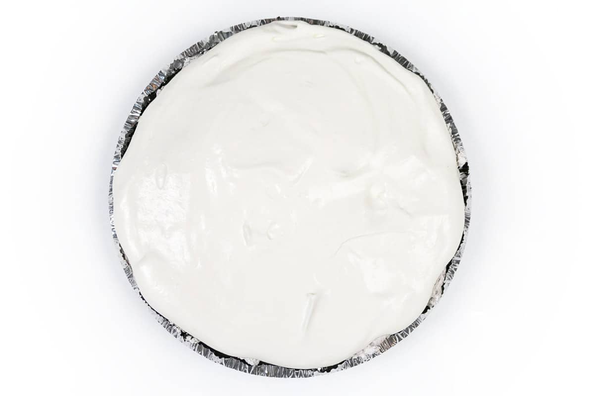 Homemade whipped cream is spread across the top of the Oreo cheesecake.