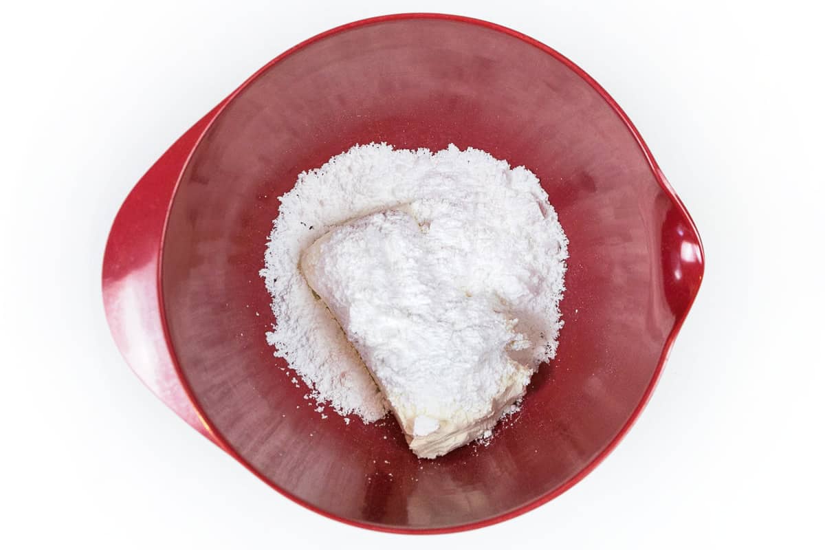 Eight ounces of softened cream cheese and one-half cup of powdered sugar in a bowl.