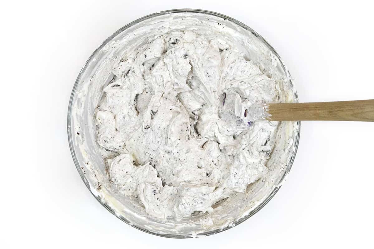 Mix the crushed Oreo cookies and Cool Whip thoroughly with the cream cheese mixture.