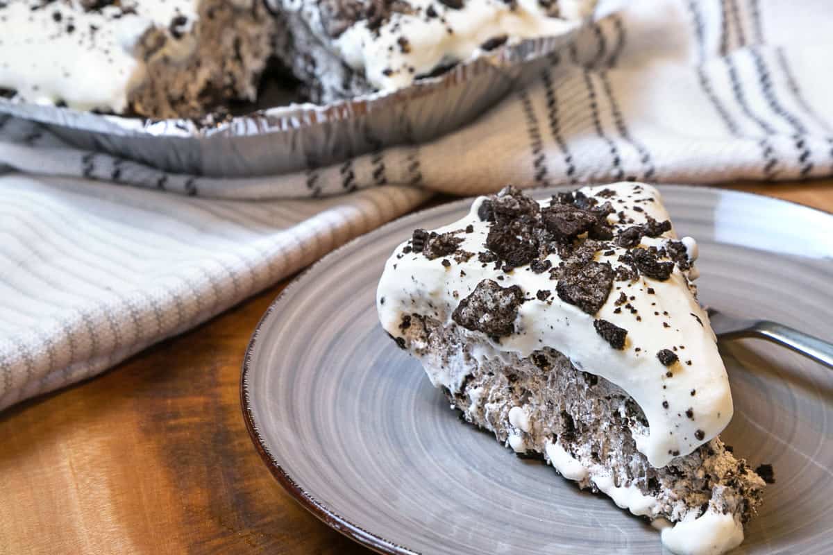 A slice of Oreo cheesecake on a plate after it has chilled in the refrigerator for six hours.