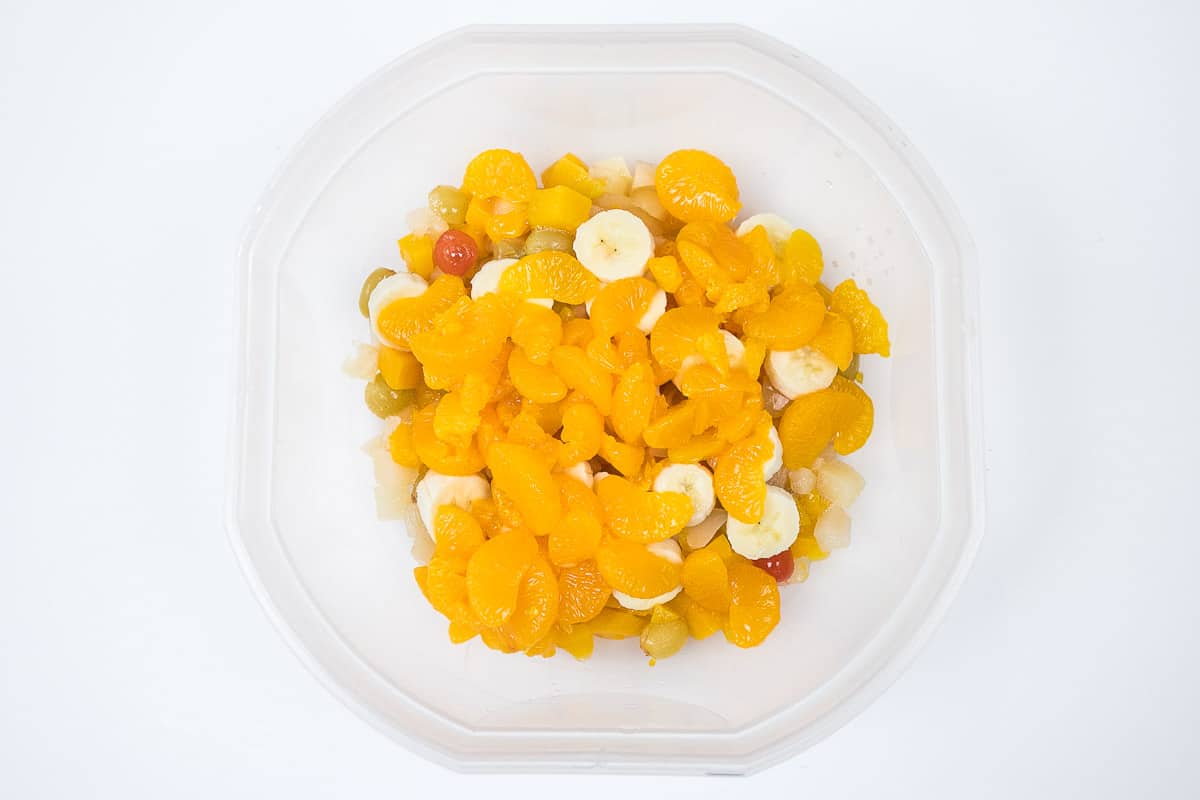 Add Mandarin oranges to the fruit cocktail salad and bananas.