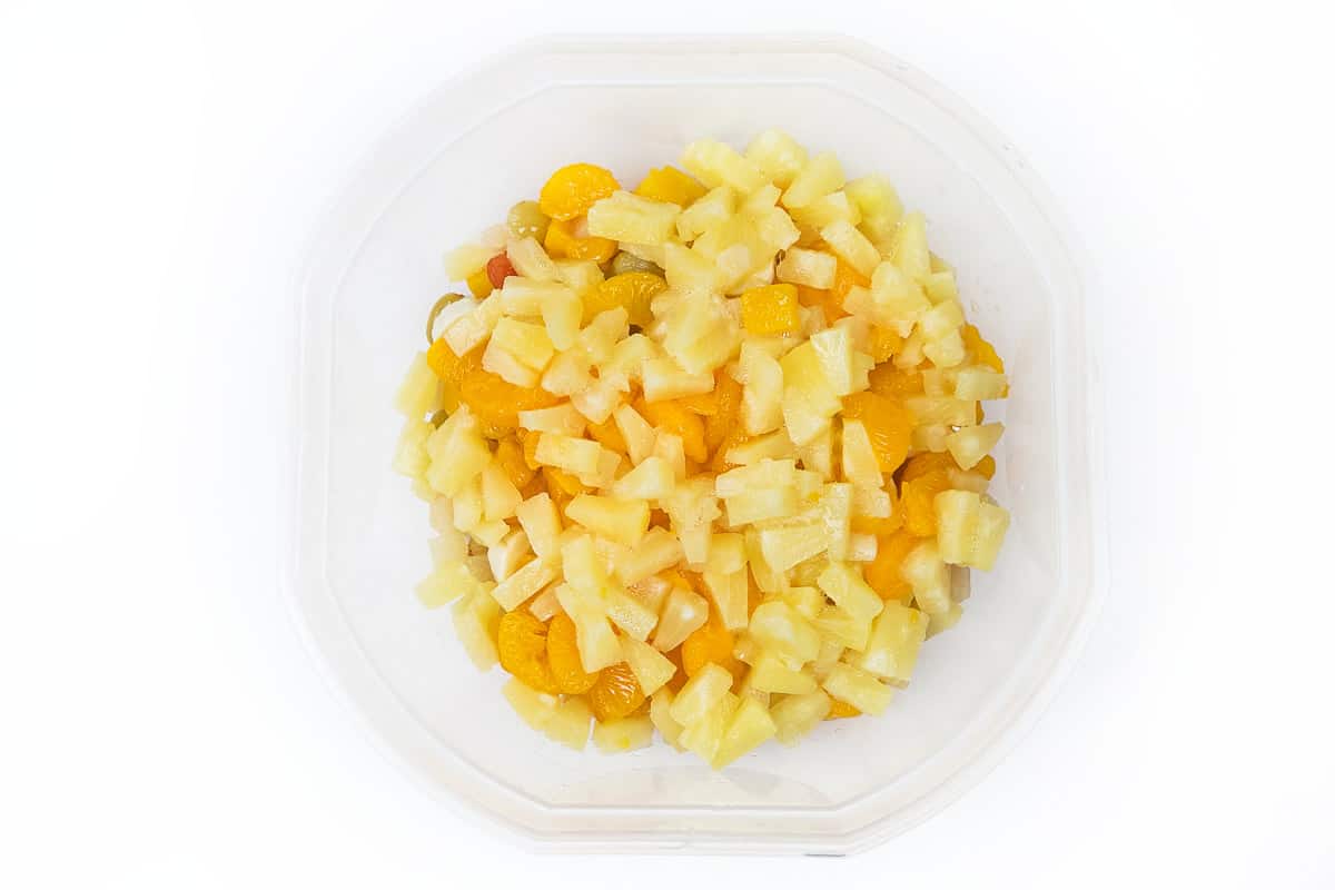 Add in the pineapple tidbits to the fruit cocktail salad.