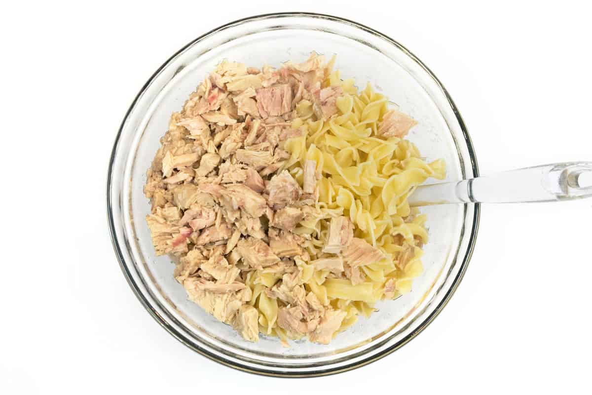 The drained tuna is added to the cooked egg noodles.