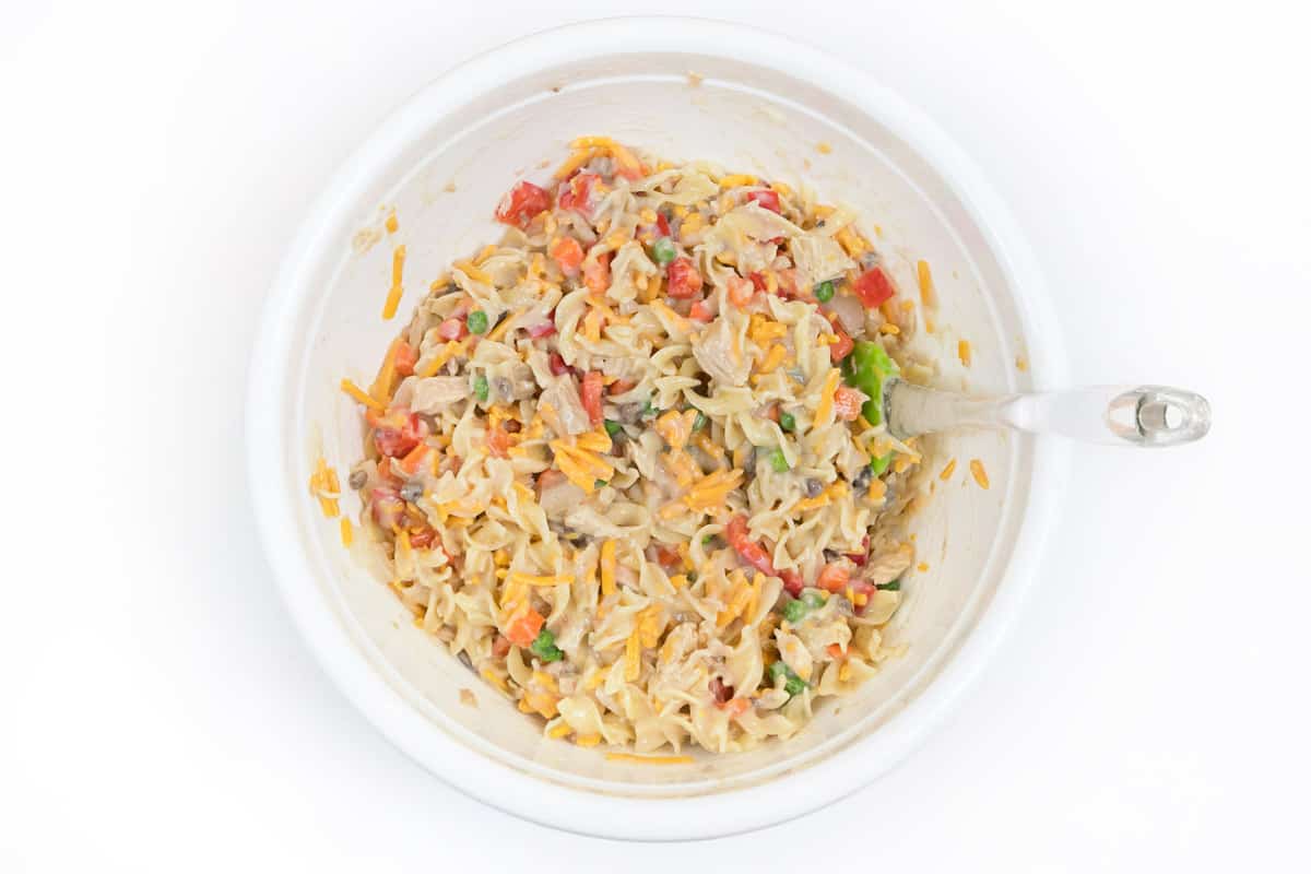 Tuna noodle casserole ingredients mixed in a bowl.