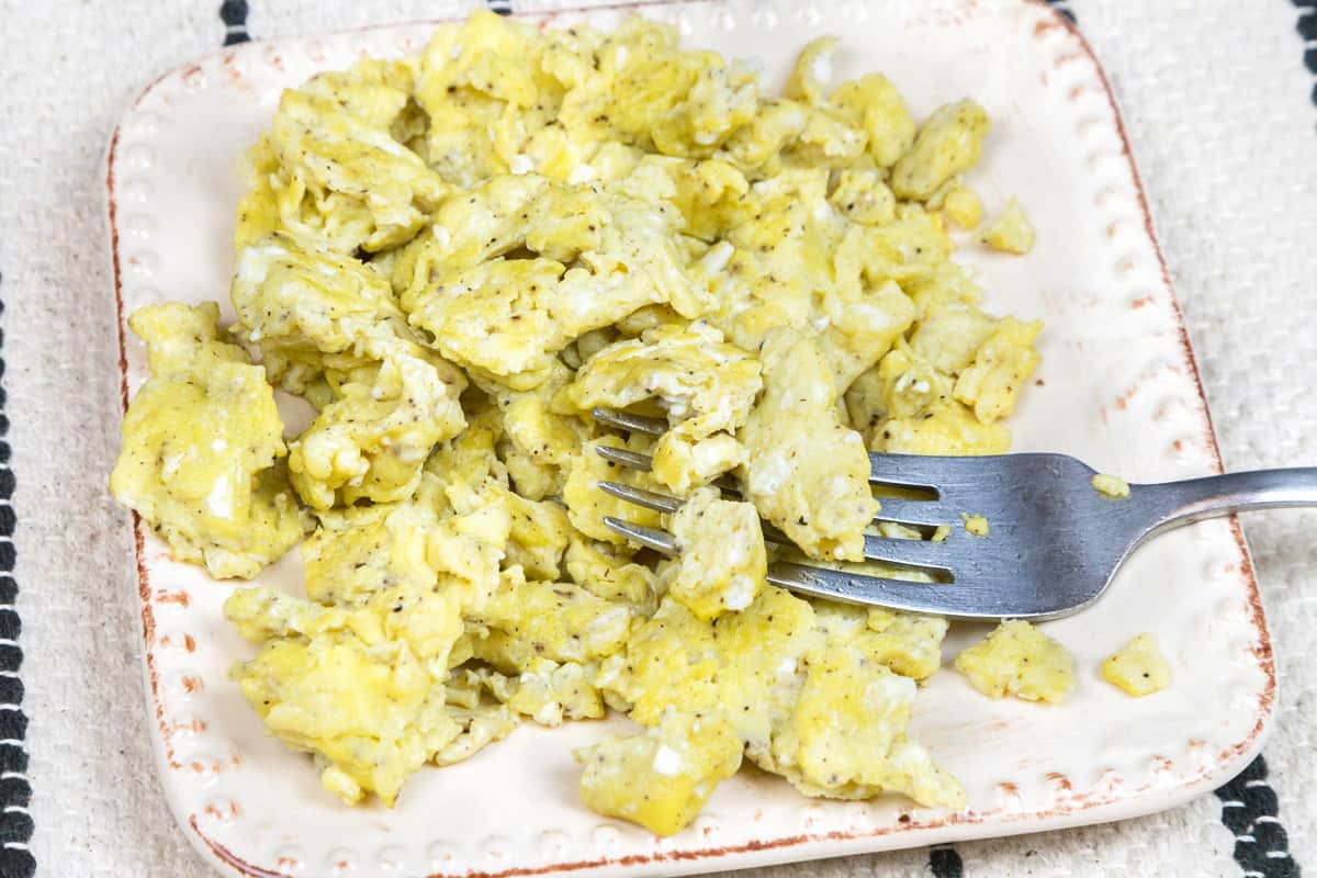 Olive oil scrambled eggs made without milk on a plate.
