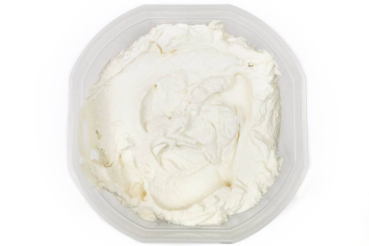 The whipped cream mixture is transferred to a large freezer-safe container, then put into the freezer for ten minutes.