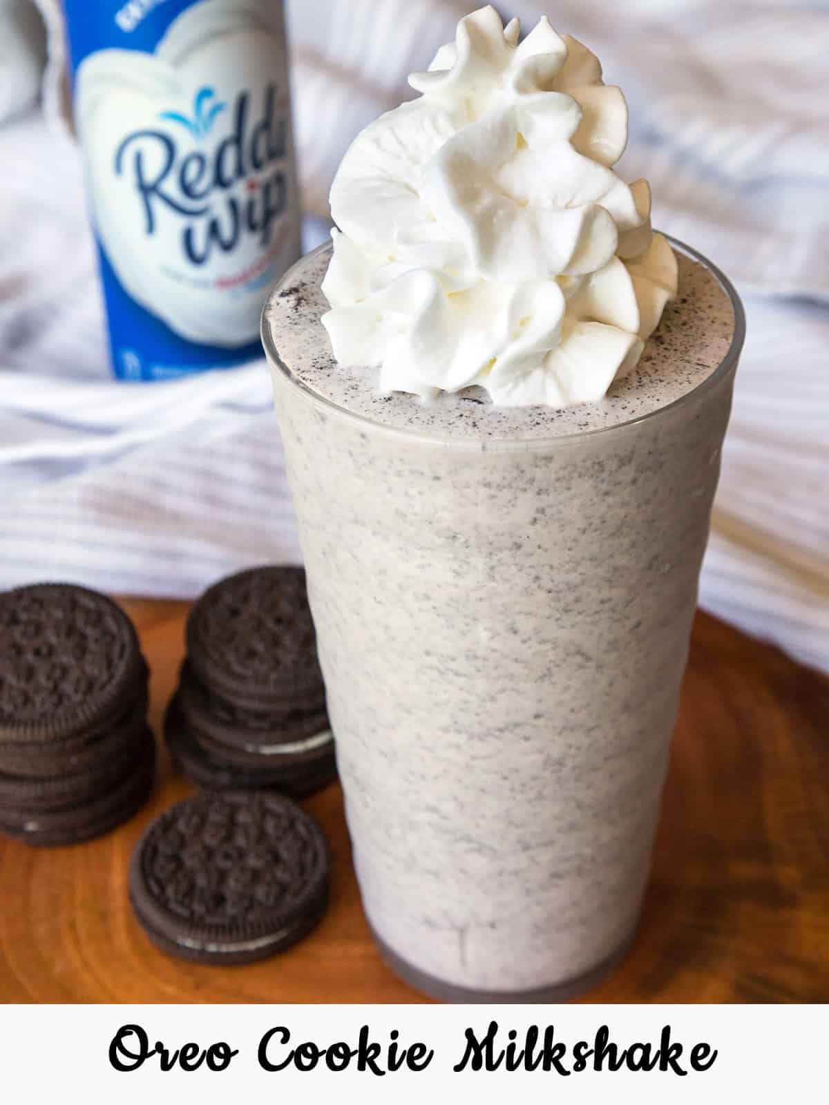 Oreo milkshake recipe with vanilla extract in a cup and topped with whipped cream.