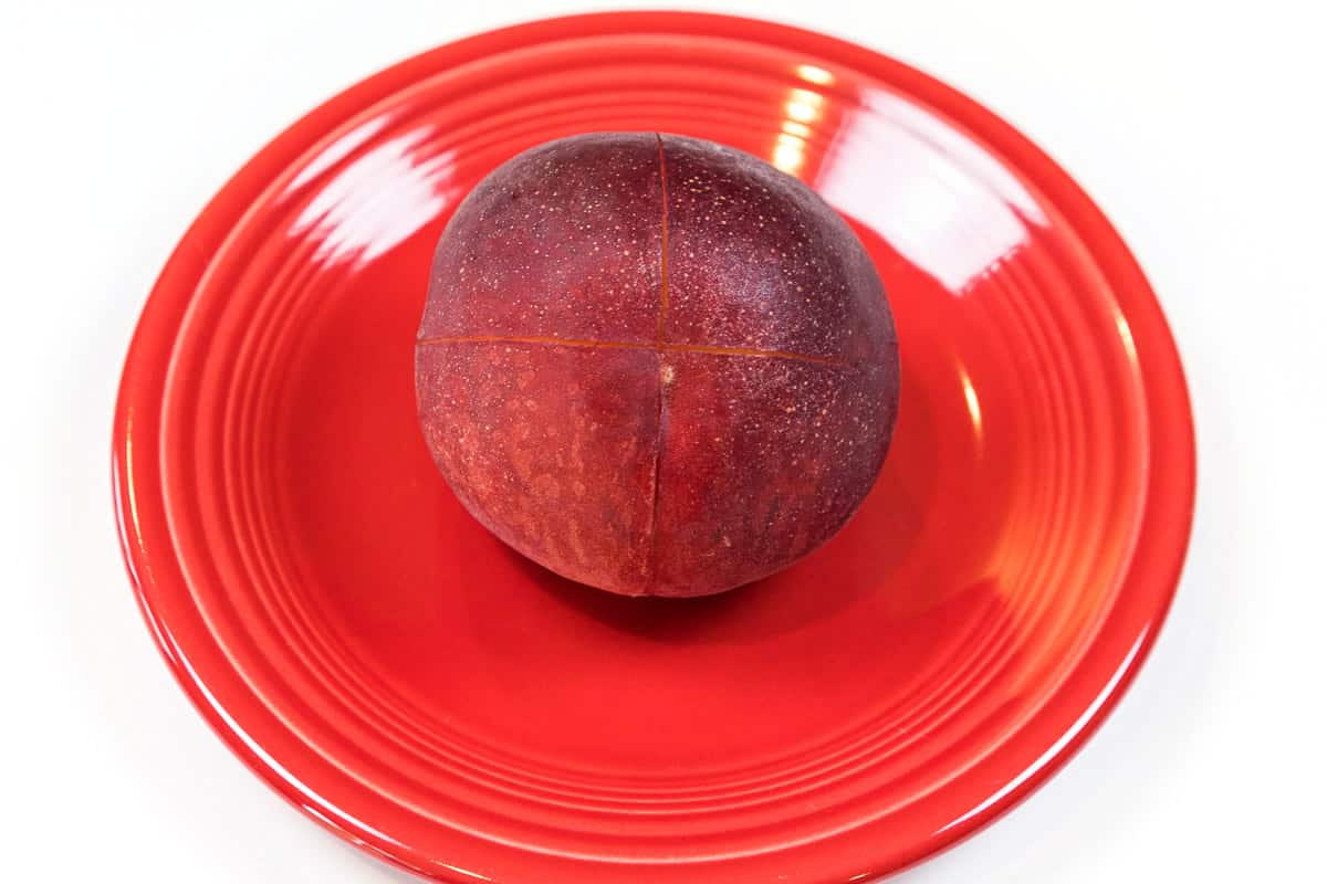 A peach that is scored for the peach bread recipe