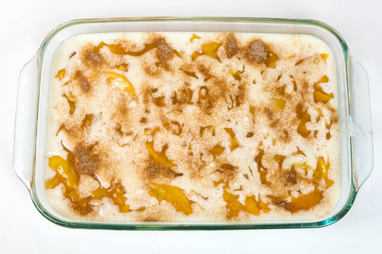The remaining Bisquick mixture and the sugar and cinnamon mixture are added over the top of the cobbler.