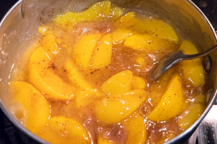 Cinnamon and sugar are added to the peaches.