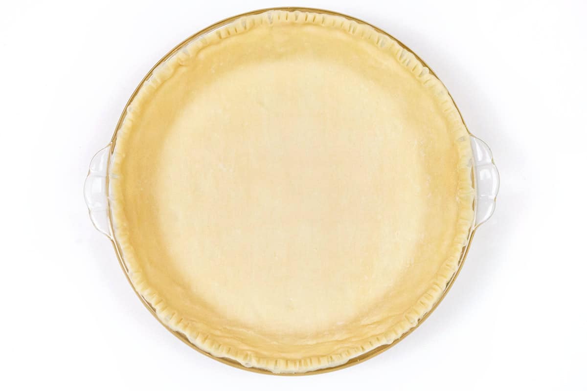 A nine-inch pie dish with a bottom crust in it.