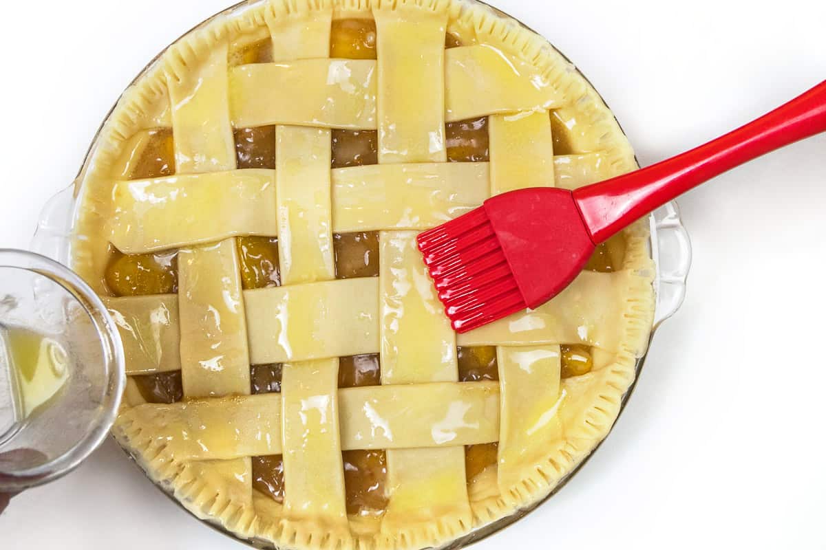 Use a pasty brush to apply melted butter over the top of the lattice top.