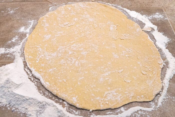 Pierogi dough rolled out on counter top.