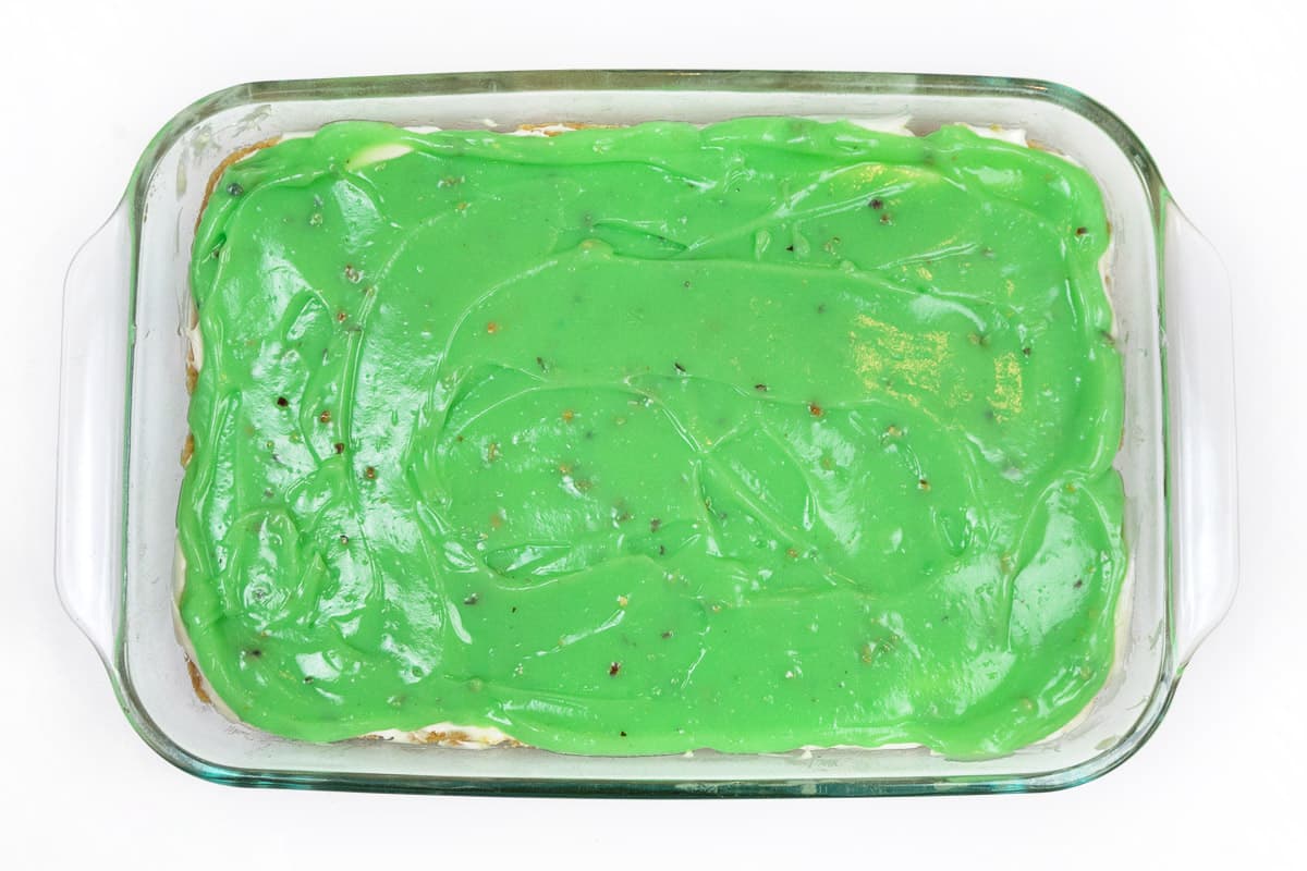 The instant pistachio pudding mixture is spread on top of the cream cheese layer.