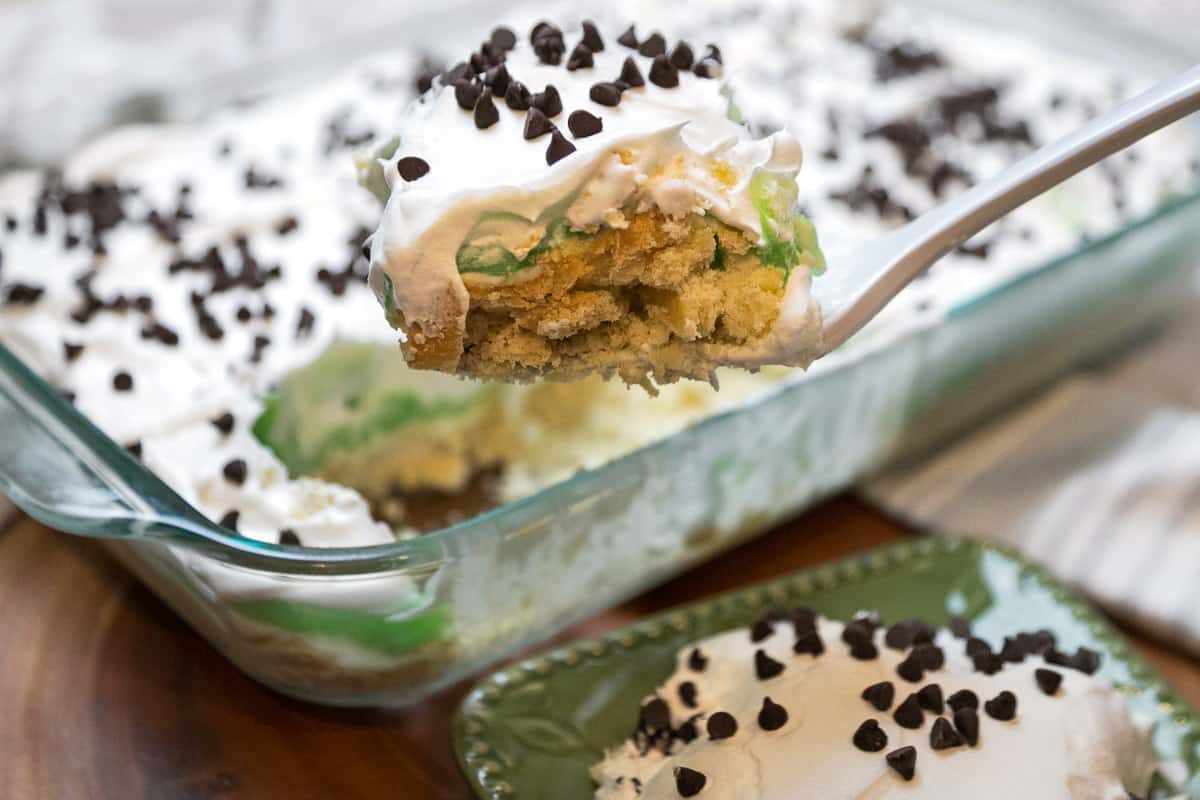 A bite of pistachio pudding dessert on a fork.