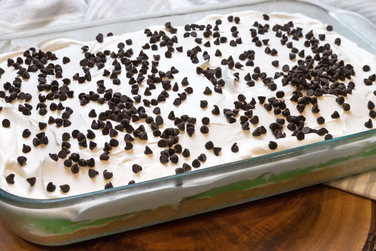 A layered pistachio pudding dessert in a nine by thirteen inch baking dish.